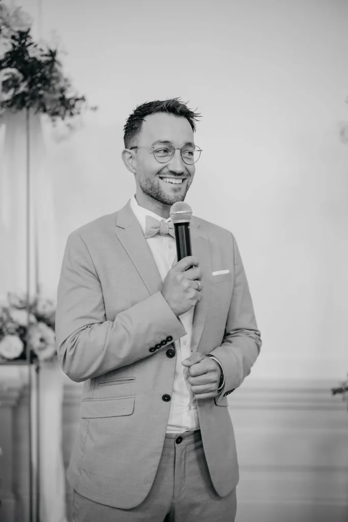 Schwarz-Weiß-Porträt von Moderator Phil Dienberg mit Mikrofon