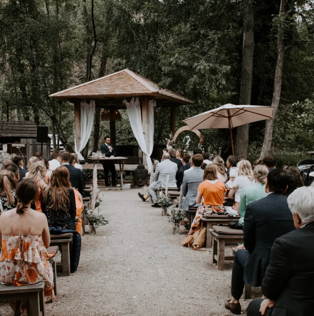 Gäste bei einer freien Trauung unter freiem Himmel mit Pavillon im Wald