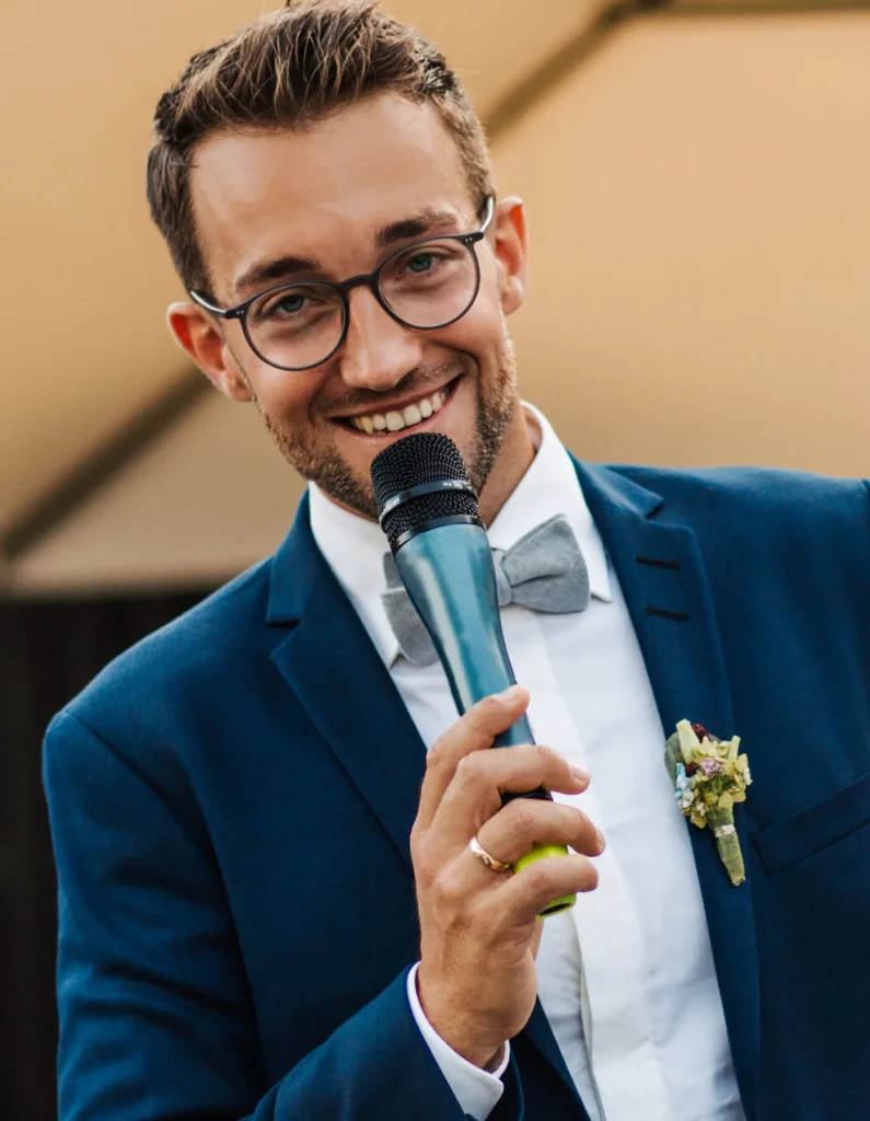 Trauredner Phil Dienberg im blauen Anzug mit Mikrofon